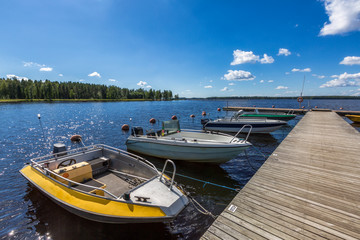 Fototapeta na wymiar Pier with motor boats on the lake
