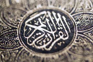 Fototapeta na wymiar Closeup shot of Islamic Book Quran with golden arabic calligraphy that means Al-Quran, the Holy Quran
