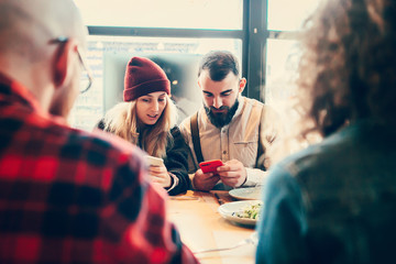 Couple rest in cafe and look to mobile phone .