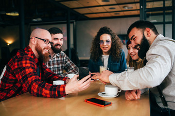 Friends communicate in cafe with mobile phone.