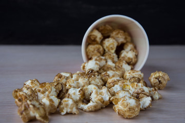 Sweet popcorn on the table. Popcorn in the pink bucket. Snack for the movies. Cinema set. Unhealthy food.