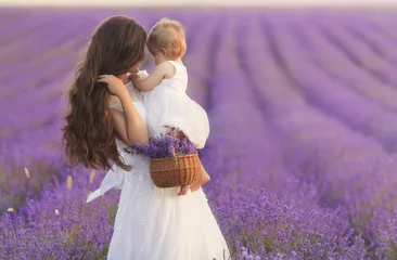 Foto op Canvas Happy beautiful mother and cute little daughter have fun in aroma lavender fields. Family holiday in summer day. © Evgeniya Grande