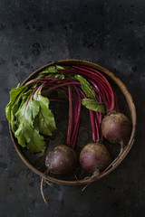 Overhead view of beets in a basket on slate background