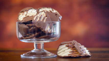 Sweet and salty snacks, chocolate covered salt and vinegar potato chips, macro close up on rustic...