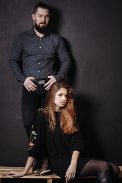 Stylish Fashion couple over black backgroung in trendy casual look. Fashion black dress and shirt in small dot.