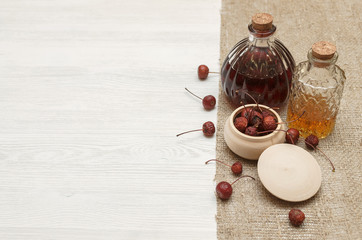 Herbal medicine. Alternative medicine concept. Dry organic natural ingridients. Wild berry and and medicinal tincture on white background with copy space.