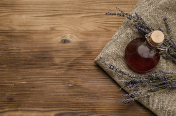 Herbal medicine. Alternative medicine concept. Dry organic natural ingridients. Healing tincture beverage and dry lavender branches on the table.