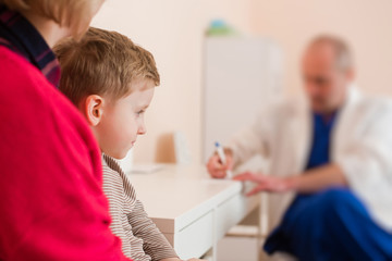 Pediatrician write a prescription for boy