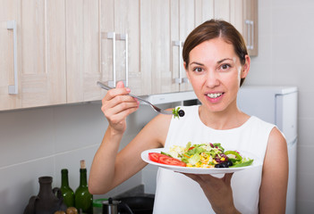 smiling woman eating salad