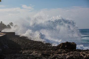 Fototapeta na wymiar Tropical beach break, ocean wave crushing stone coastline, water splashes