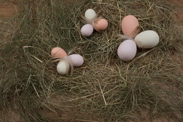 Easter basket on table with hay and blackboard with inscription