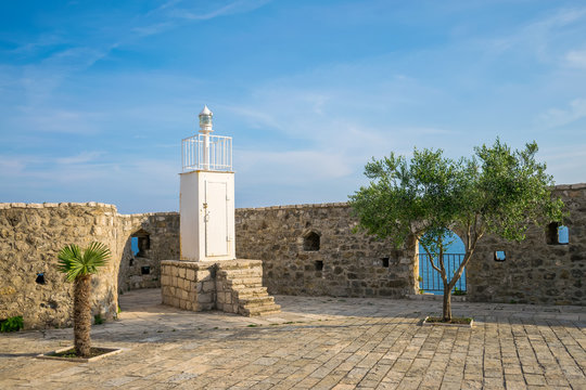 White lighthouse in the old fortress provides safe navigation of ships.