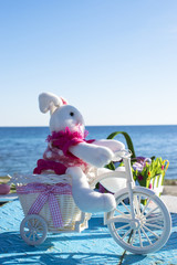 Easter bunny with colored eggs on background of spring nature on the beach