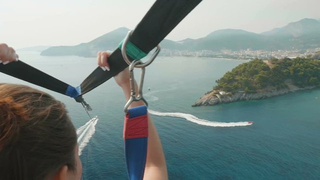 Parasailing water amusement. Flying on a parachute behind a boat in Montenegro