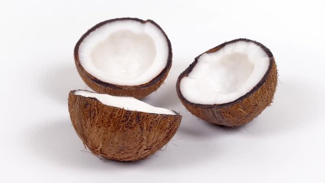 Three ripe tropical coconut halves with yummy white pulp rotating on white isolated background. Healthy fresh tropical fruits. Loopable seamless cocos rotating