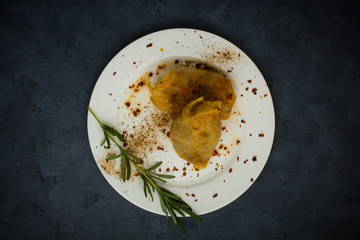 Cabbage rolls on a white plate with rosemary, restaurant feed, top view