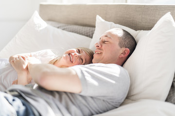 Father and daughter enjoying time in white bed