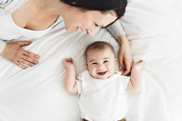 Mother with a baby on bed at home