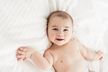 Portrait of a baby boy on the bed in bedroom