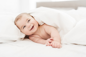 Portrait of a baby boy on the bed in bedroom