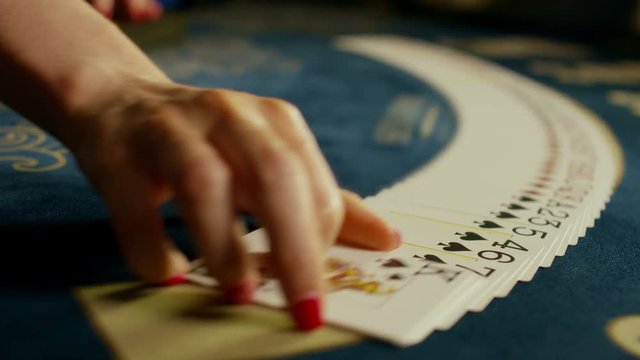 Casino: Dealer woman shuffles the poker cards and performing trick with cards. Shot on RED EPIC DRAGON Cinema Camera in slow motion.
