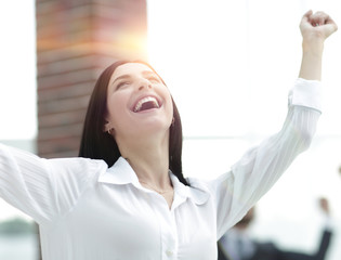 Fototapeta premium happy young business woman on a blurred office background.