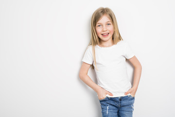 Obraz premium Happy small five years old girl with straight hair over white background at home