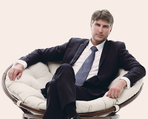 Tired business man sitting in a large comfortable chair