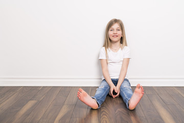 Happy small five years old girl with straight hair over white background at home