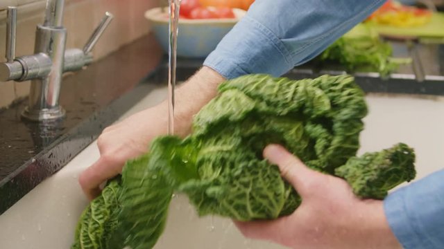 Man Hands Removing Leaves While Washing Savoy Cabbage In Sink