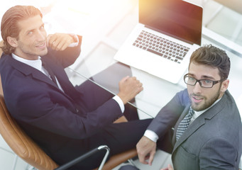 successful employees sitting behind a Desk