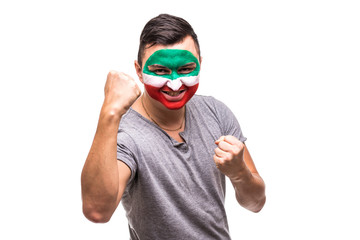 Handsome man supporter fan of Iran national team painted flag face get happy victory screaming into...