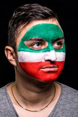 Portrait of handsome man face supporter fan of Iran national team with painted flag face isolated on black background. Fans emotions.