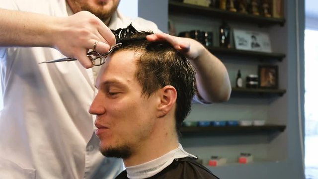 Hairdresser makes Iroquois man in barbershop
