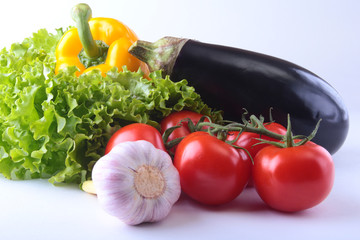 Fresh assorted vegetables, eggplant, bell pepper, tomato, garlic with leaf lettuce. Isolated on white background. Selective focus.