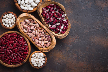 Assortment of various beans in wooden bowls 