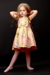 Naklejka premium Little girl on a black background