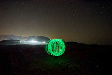 green light ball at night with many stars
