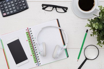 Office desk table layout with headphones and supplies