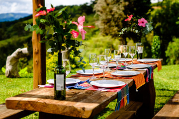 Table set for family in beautiful location. Wooden table, flower