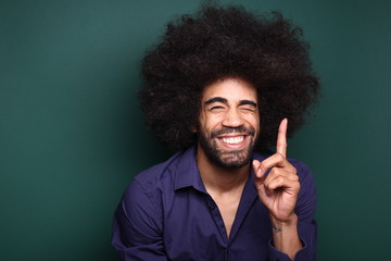 Afro man in front of a green background