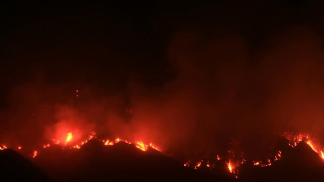 Night fire moving down mountain - time lapse