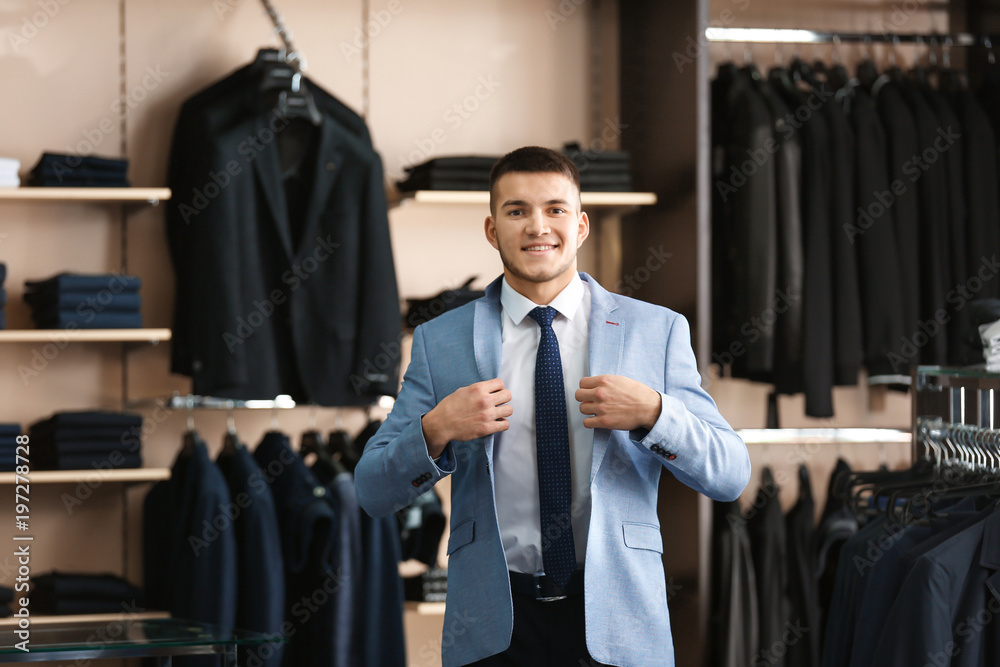 Wall mural Young man trying on elegant suit in boutique