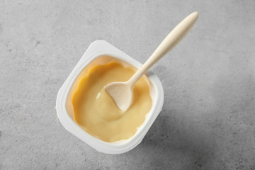 Plastic cup with yummy yogurt on table