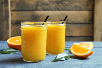 Jars of orange juice and fresh fruits on table
