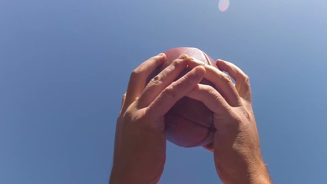 Slo-mo of a football being caught by receiver