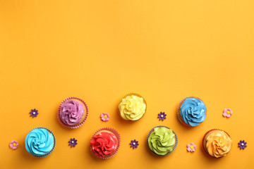 Delicious birthday cupcakes on color background