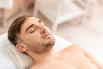 Fototapeta na wymiar Young man relaxing in spa salon