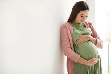 Young pregnant woman in casual clothes indoors