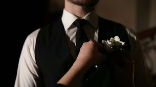 A groom's friend wears a boutonniere